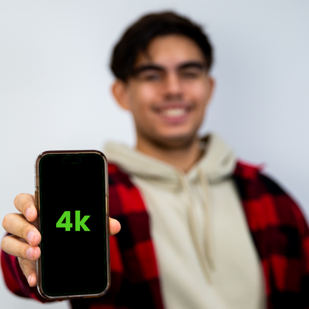 Mobile To Desktop Video Optimization, Digital Marketer Holding Phone with 4k Displayed